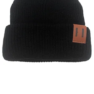 Classic black ribbed knit beanie for babies and toddlers with a vintage brown leather patch