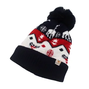Gedetailleerde gebreide textuur van kerstmuts met rendierpatroon en een donkerblauwe pompon