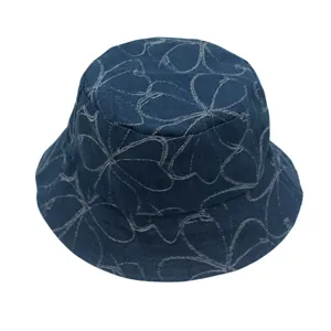 Detalle de gorro de pescador en denim azul oscuro con patrón floral y costuras finas