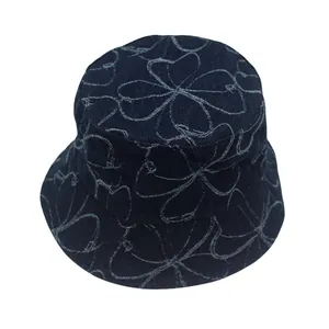 Detalle de gorro de pescador en denim azul oscuro con diseño de trébol y tejido grueso