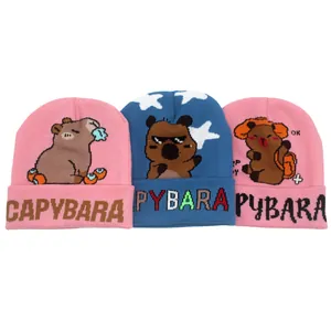 Dettaglio dei berretti Capybara in maglia con motivi jacquard in rosa e blu scuro