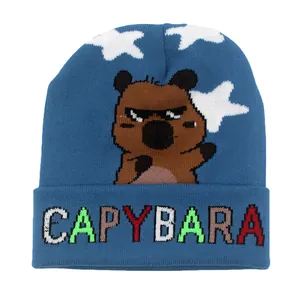 Dettaglio del berretto in maglia blu con disegno capibara e scritte colorate ricamate