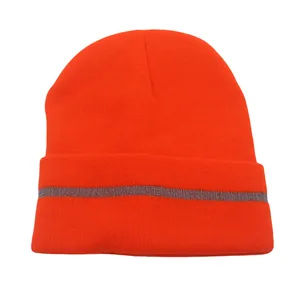 Detail view of bright orange knit beanie featuring a grey reflective safety stripe for outdoors