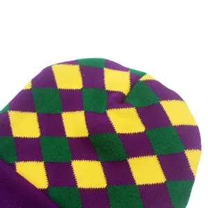 Détail macro de la texture tricotée et du motif losange violet vert jaune sur le bonnet