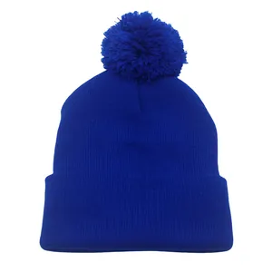 Dettaglio della maglia di un berretto blu reale con pompon e bordo con risvolto