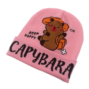 Dettaglio della trama in maglia del berretto rosa capybara con scritte e un cartone