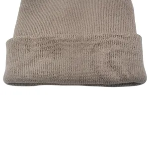 Dettaglio del berretto in maglia beige con trama a coste verticali e ampio bordo risvoltato