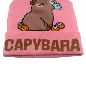 Dettaglio ravvicinato del berretto in maglia rosa Capybara con jacquard e trama fine