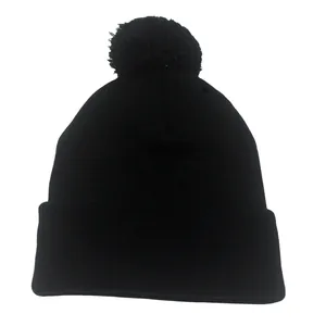 Classico berretto in maglia nera con un pompon coordinato in cima e un bordo risvoltato
