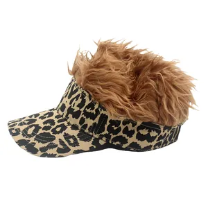 Detail of leopard print visor with shaggy brown wig hair on a white background