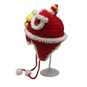 Red knit baby lion dance hat with colorful pom poms and fleece lining for winter warmth