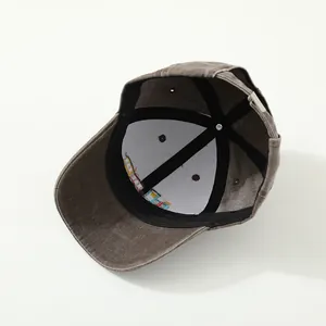 Detail of vintage washed baseball cap featuring cartoon train embroidery and metal buckle