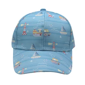 Détail d'une casquette enfant bleu clair avec motifs nautiques de phares et bateaux à voile