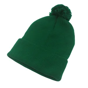 Dettaglio berretto in maglia verde scuro con pompon e trama a costine rifinita