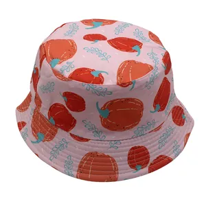 Detail of pink kids bucket hat with red pumpkin and blue leaf patterns on canvas fabric