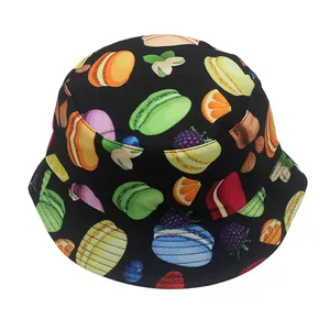 Detalle de gorro de pescador infantil con estampado de macarons y frutas sobre tela negra