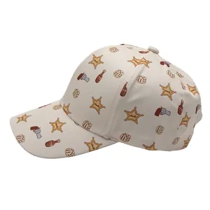 Détail de casquette enfant avec motifs shérif et cowboy sur un tissu de couleur crème