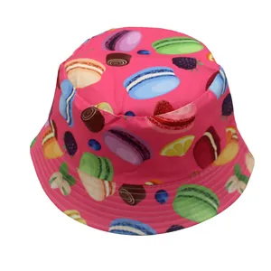 Vista detallada del sombrero rosa con estampados de macarons y frutas con borde reforzado