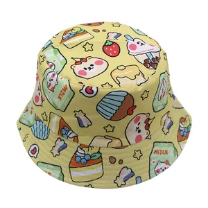 Close-up of yellow kids bucket hat featuring cute cartoon bear and cake pattern prints