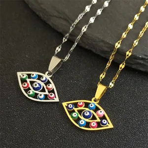 Gold and silver evil eye pendant necklaces with colorful enamel on dark stone background