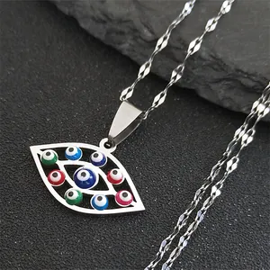 Macro detail of silver evil eye pendant with colorful beads on a dark stone background