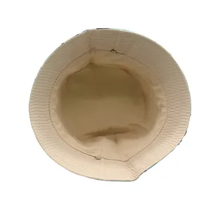 Dettaglio ravvicinato del cappello a secchiello beige con trama a nido d'ape e cuciture