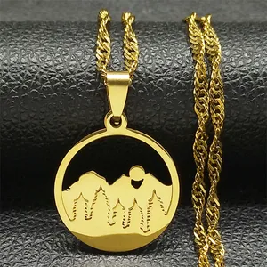Detail of a gold-plated stainless steel necklace with a hollowed mountain forest pendant