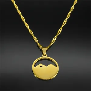 Detail showing a gold layered necklace with circular mountain silhouette pendant on twist chain