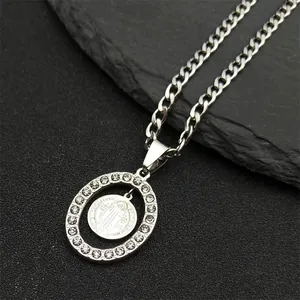 Macro shot of silver Cuban chain with Saint Benedict medal pendant and diamond frame