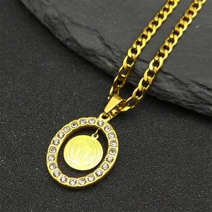 Detail of St. Benedict medal pendant with rhinestones and gold Cuban link chain