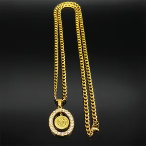 Detailed view of Saint Benedict gold pendant with cubic zirconia on a cuban chain link
