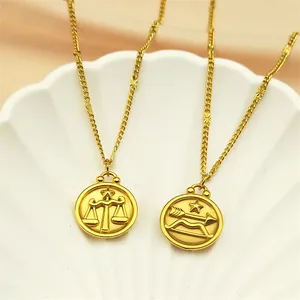 Détail de pendentifs du zodiaque Balance et Sagittaire dorés avec étoiles en relief sur plateau