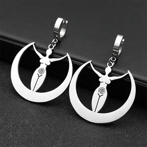 Detail of silver goddess earrings with crescent moon and spiral on dark background