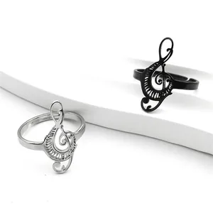 Minimalist musical treble clef open ring in silver and black metal on display stand