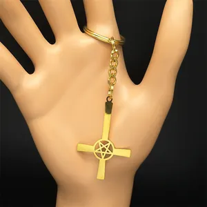 Gothic gold metal inverted cross keychain with pentagram pendant on black background