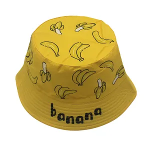 Detailed close-up of yellow cotton bucket hat with cartoon banana patterns and text