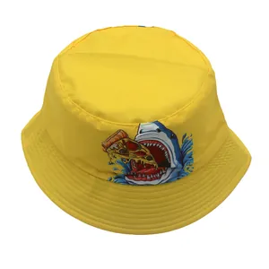 Close-up of a yellow kids bucket hat featuring a cartoon shark eating pizza print