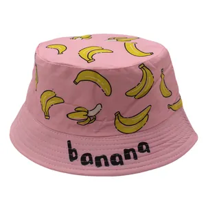 Detail of pink cotton bucket hat featuring yellow banana prints and black text