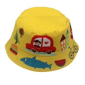 Détail d'un chapeau bob enfant jaune avec imprimés voitures et maisons colorées
