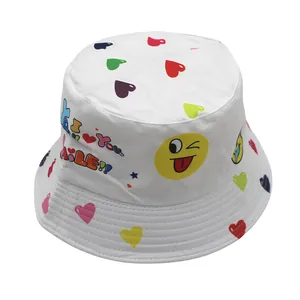 Close-up of white canvas bucket hat featuring colorful smile emojis and heart patterns