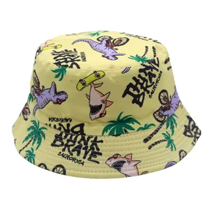 Kids yellow bucket hat featuring cartoon dinosaur prints and Brave California text