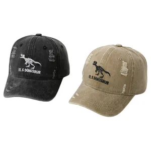 Detailed view of dinosaur skeleton embroidery and vintage distressed fabric on baseball caps
