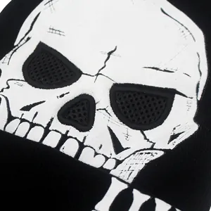 Détail d'un bonnet en maille noire avec motif tête de mort stylisé et détails en maille