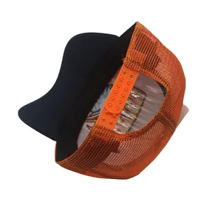 Détail de la fermeture snapback orange et du filet respirant sur la casquette trucker