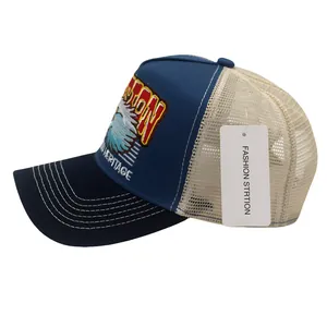 Détail de la broderie aigle Boston Heritage sur casquette trucker bleue et beige
