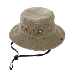 Dettaglio cappello pescatore in cotone kaki con ricami di veicoli e corda antivento