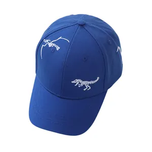 Detailed close-up of white dinosaur skeleton embroidery on a blue cotton baseball cap
