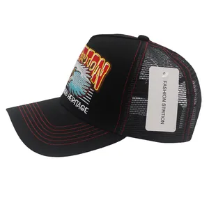 Détail de la broderie aigle et surpiqûres rouges sur la casquette trucker noire en mesh