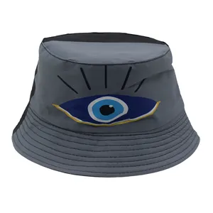 Detailansicht des grau-schwarzen Fischerhuts mit aufgesticktem Evil-Eye-Muster auf der Front