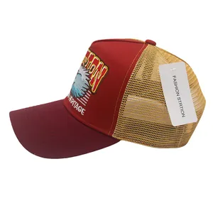 Détail de la broderie d'aigle vintage et filet sur la casquette trucker rouge et jaune